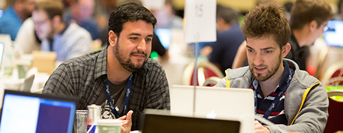Two engineers collaborate at the AWS re:Invent Hackathon.